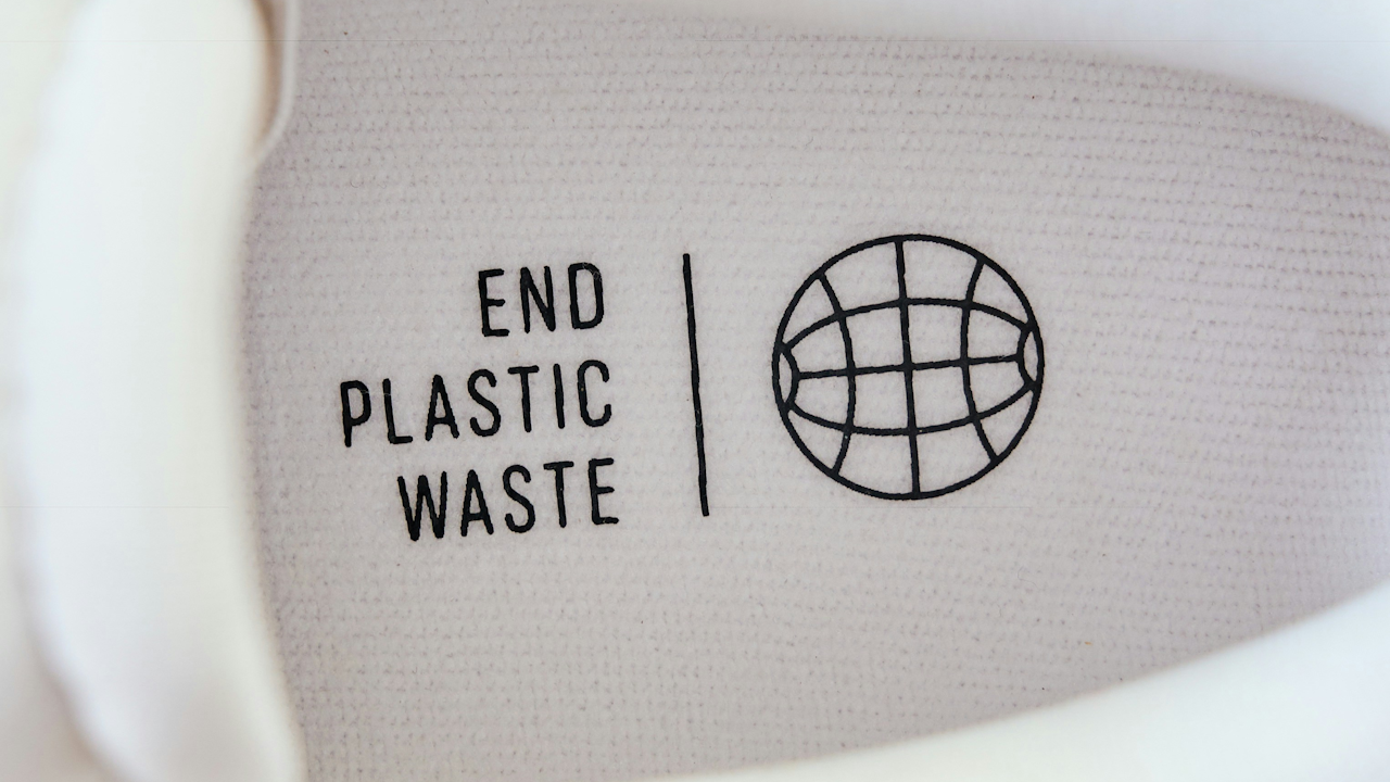 A label on a sports shoe that reads "END PLASTIC WASTE."