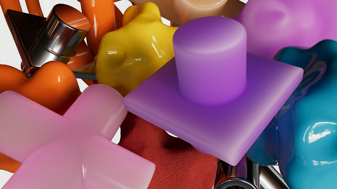 Colorful abstract 3D shapes in orange, purple, pink, yellow, and blue, with metallic and glossy textures, arranged chaotically.