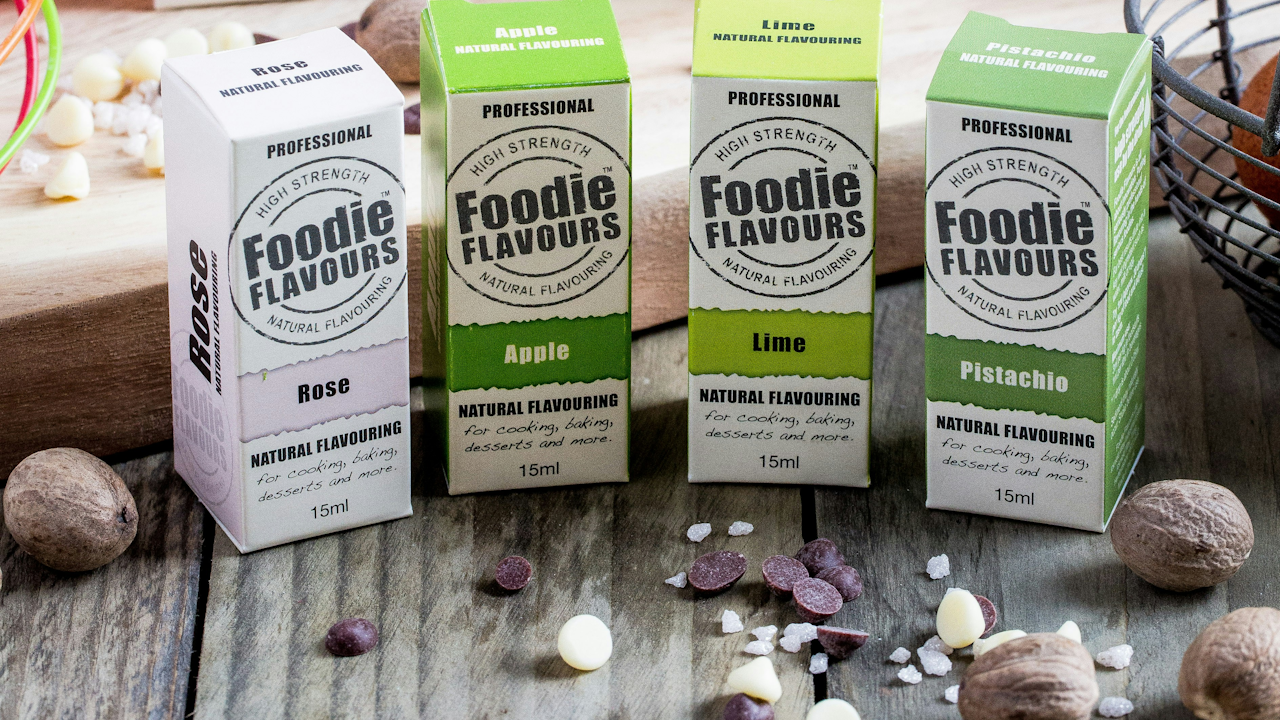 A group of boxes containing various food items, including bottles labeled with different flavors such as apple lime and pistachio, displayed indoors.