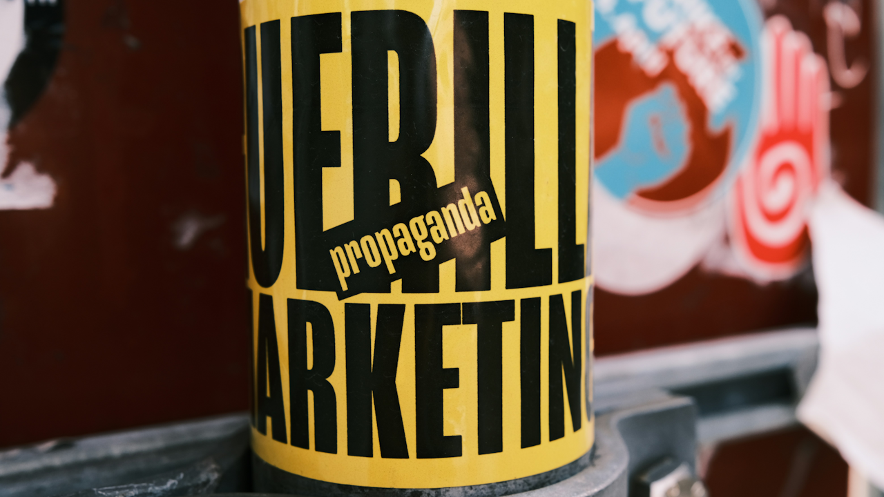 A yellow can with black text labeled "GUERRILLA MARKETING propaganda" representing a beverage container, possibly a soft drink or beer.