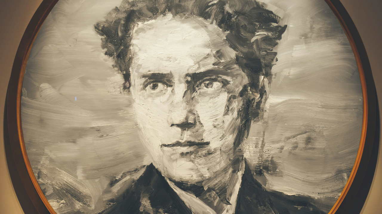 A monochrome portrait of the Irish revolutionary and politician Michael Collins. The painting, done with bold, visible brushstrokes, shows his head and shoulders. His expression is serious, and he's looking directly at the viewer. The portrait is in an oval frame.